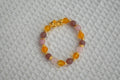 Beaded crystal bracelet with gold Piyao and accents on a textured fabric background
